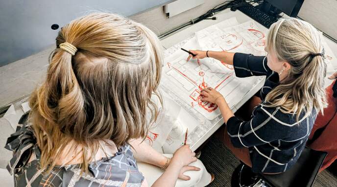 PLA group of employees looking over drawing documents